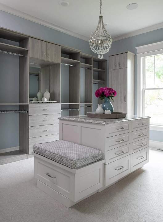 blue walls with gray cabinetry an island and a seat