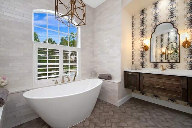 large bath tub with subway tiles and brown vanity