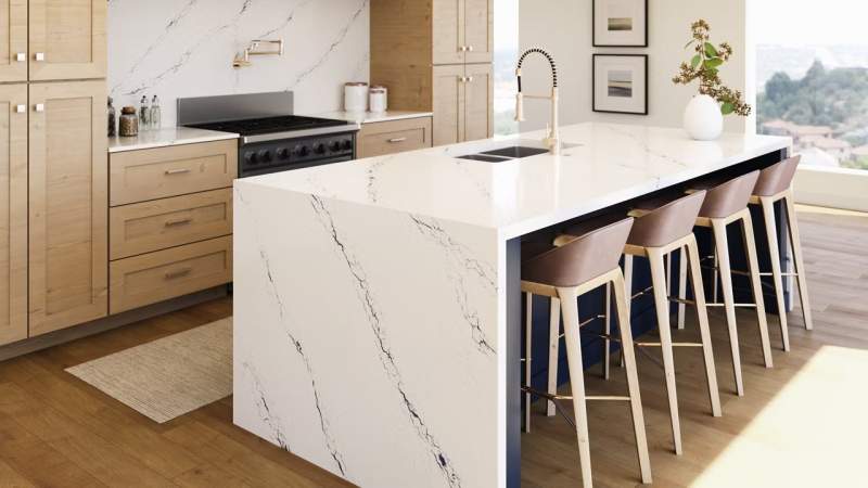 stunning white quartz counter top with blue veining  as waterfall island with natural wood cabinetry 