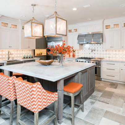 white cabinetry with a weathered gray island and orange chairs